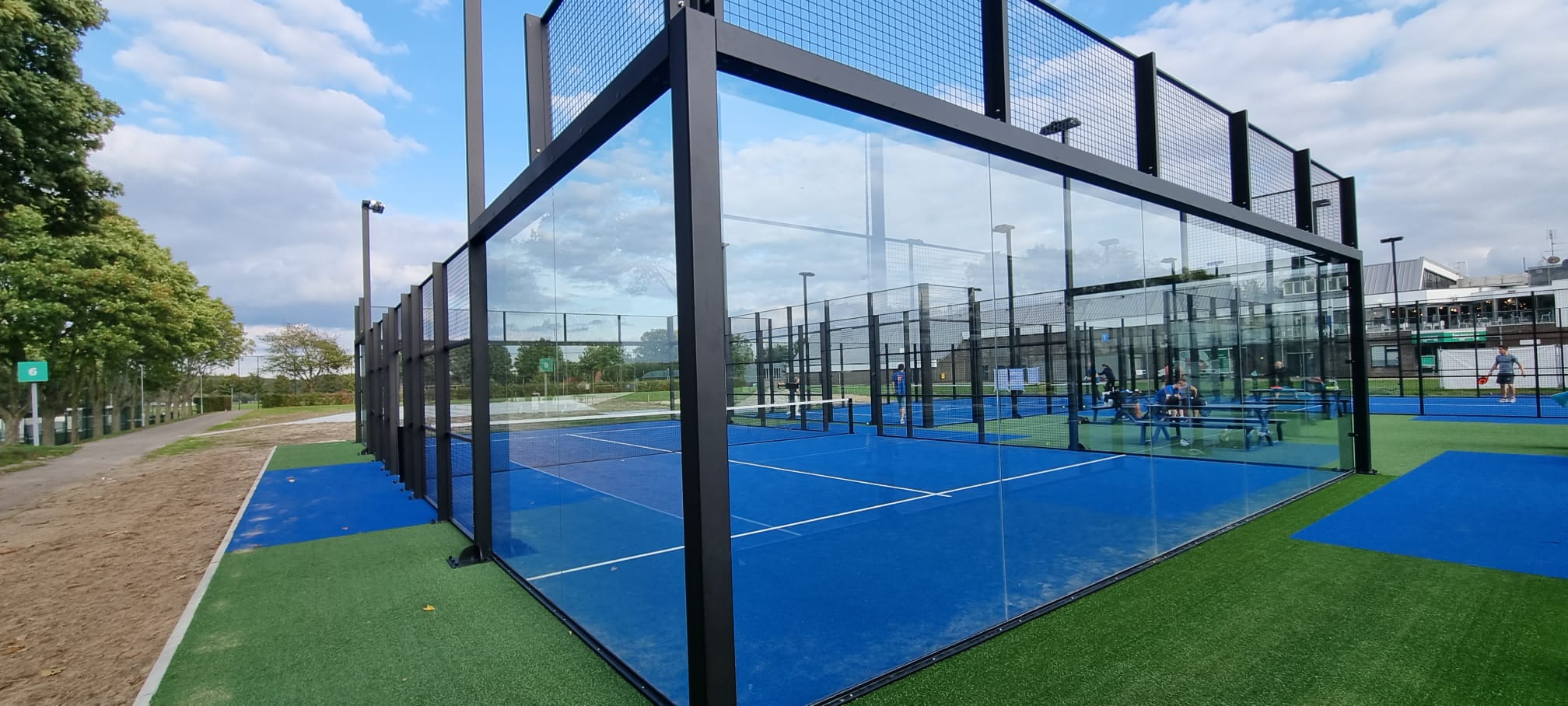 Aanleg van tennisbaan in progressie, met zicht op fundering